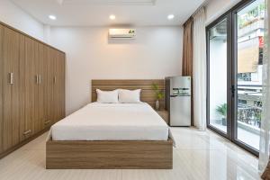 a bedroom with a bed and a refrigerator at ViVo 416 Apartment in Ho Chi Minh City