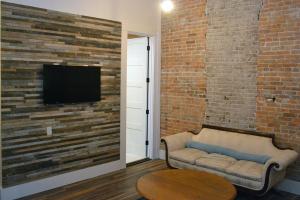 a living room with a couch and a tv on a brick wall at Eighteen-Ninety Sleepover in Casey