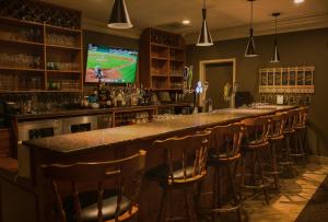 a bar with a row of bar stools and a television at Maritime Inn Port Hawkesbury in Port Hawkesbury