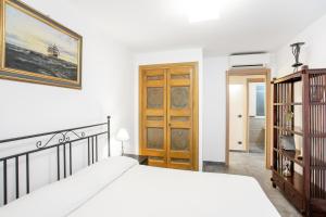 sypialnia z łóżkiem i drewnianymi drzwiami w obiekcie Penelope Seaview Apartment w Katanii