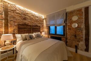 sypialnia z łóżkiem i ścianą z cegły w obiekcie Arechaga AC by Staynnapartments w mieście Bilbao