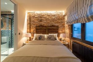 sypialnia z dużym łóżkiem i ceglaną ścianą w obiekcie Arechaga AC by Staynnapartments w mieście Bilbao