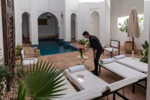 a man standing in a living room with a pool at Riyad El Cadi in Marrakesh
