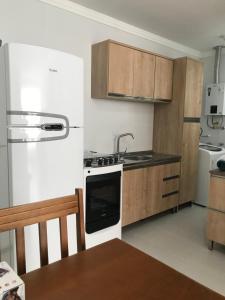 uma cozinha com um lavatório e um fogão forno superior em Espaço Luanda - Ingleses Florianopolis em Florianópolis