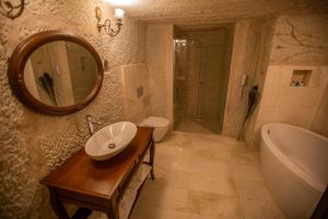 a bathroom with a sink and a tub and a mirror at Lavender Cave Hotel in Nevşehir