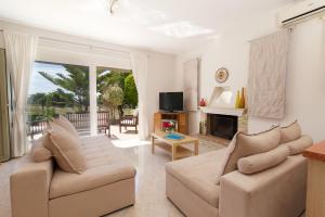 a living room with two couches and a fireplace at Sunnyside House Kefalonia in Kefallonia