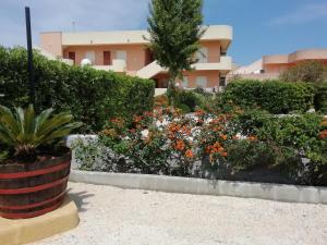 un jardín de flores frente a un edificio en Stella di Mare Appartamenti, en Marsala