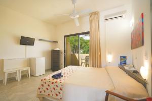 a bedroom with a bed and a sliding glass door at Hotel Le Acacie in Capoliveri