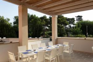 a table and chairs on a patio with trees at Masseria Mongiò dell'Elefante in Otranto