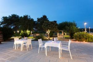a white table and chairs on a patio at night at Masseria Mongiò dell'Elefante in Otranto
