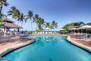 - une piscine avec des chaises et des palmiers dans l'établissement Inviting condo with pool & beach access, à Miami Beach