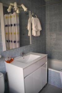 een badkamer met een wastafel, een spiegel en een bad bij Hotel Restaurante Valdevenados in Anguiano