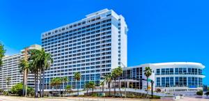 a large building with palm trees in front of it at Oceanfront studio with ocean view, easy beach access and free parking! in Miami Beach