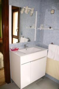 uma casa de banho com um lavatório branco e um espelho. em Hotel Restaurante Valdevenados em Anguiano
