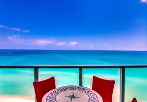 a table and chairs on a balcony with the ocean at Castle Ph3 in Miami Beach
