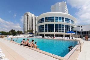 a group of people sitting in a swimming pool in front of a building at Oceanfront Townhouse with direct access to the Beach! Steps from the sand! in Miami Beach