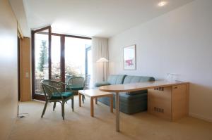 a living room with a couch and a table and chairs at Hotel Seegasthof Oberndorfer in Attersee am Attersee