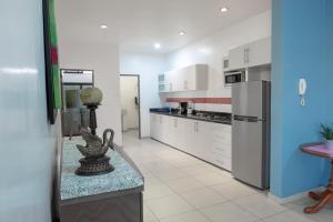 a kitchen with a refrigerator and a table in it at Apartamentos Torre II Condominios - Pet Friendly in Mazatlán