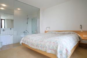 a bedroom with a large bed and a shower at Hotel Seegasthof Oberndorfer in Attersee am Attersee