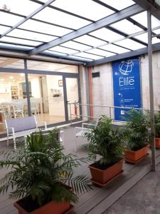um edifício com vasos de plantas e um cartaz sobre ele em Hotel Elite em Palermo