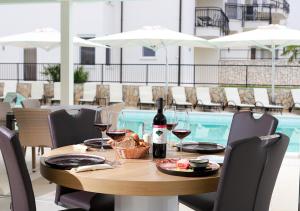 a table with a bottle of wine and wine glasses at Cool Šilo Appartement Resort in Šilo