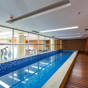 a swimming pool with blue tiles in a building at Flat Vision Hoteleiro Norte in Brasilia