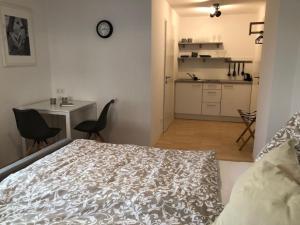 a bedroom with a bed and a kitchen with a table at SPITZAUERs APARTMENTs in Anthering +8 photos