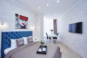 ein Hotelzimmer mit einem Bett, einem Tisch und einem TV in der Unterkunft Panoramic Plaza Apartments in Odessa