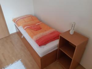 a small bed in a small room with a night stand at Apartmán Borgi in Oščadnica
