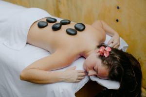 Una mujer acostada en una cama con rocas en la espalda en Natura Cabana Boutique Hotel & SPA by Mint en Cabarete