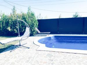 a pool with a chair and a bench next to it at Luxury 3 Bedroom Pool Villa in Gulia