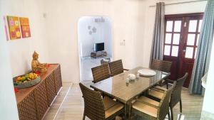 a dining room with a table and chairs and a television at Ogumka, Self catering , Beoliere, Mahe in Victoria