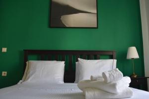 zieloną sypialnię z łóżkiem i ręcznikami w obiekcie City Life Apartments #3 w mieście Janina