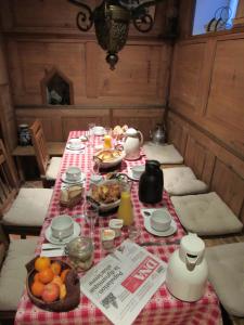 a table with a red and white table cloth with food on it at Gîte Le Vigneron in Donnenheim