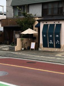 un parapluie et un panneau sur le côté d'un bâtiment dans l'établissement Utopia Wakamiya 207 / Vacation STAY 5372, à Fukuoka