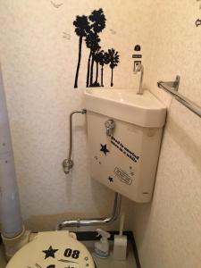 a bathroom with a toilet with stickers on the wall at Utopia Wakamiya No.105 / Vacation STAY 5161 in Fukuoka