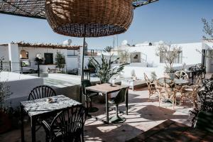 eine Terrasse mit Tischen und Stühlen auf dem Dach in der Unterkunft Dar Titrit in Marrakesch