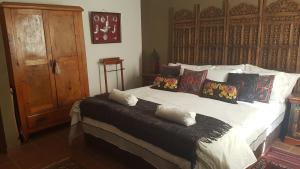 ein Schlafzimmer mit einem großen Bett mit Kissen darauf in der Unterkunft Wooden Creek Estate in Kempton Park
