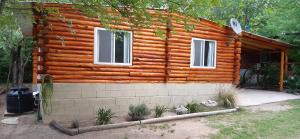 a log cabin with two windows on the side of it at Cabaña Trapiche San Luis in Trapiche