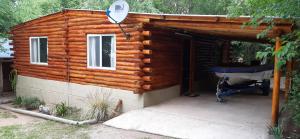 a log cabin with a porch and a grill at Cabaña Trapiche San Luis in Trapiche