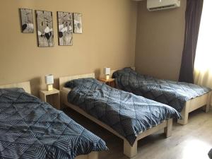 a bedroom with two beds and two lamps at Alföldi Levendula Vendégház in Cserkeszőlő