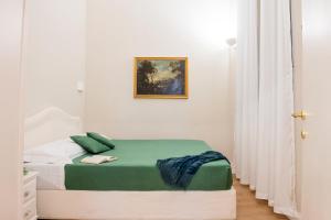 ein Schlafzimmer mit einem Bett mit einer grünen und weißen Decke in der Unterkunft SWEET DREAM CAVOUR in Rom