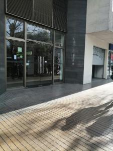 a shadow of a person walking in front of a building at San Agustín Apart in Santiago