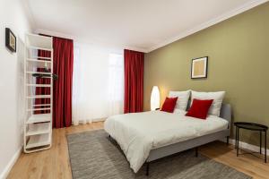 - une chambre avec un grand lit blanc et des oreillers rouges dans l'établissement Martin Boutique Hotel, à Plauen