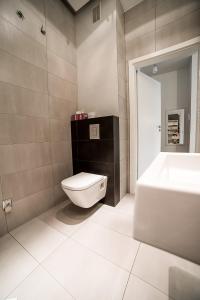 a bathroom with a toilet and a sink and a tub at Lost In Krakow Mostowa in Kraków