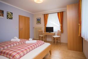 a bedroom with two beds and a desk with a computer at Säuleck Appartement mit Kärntencard in Mallnitz