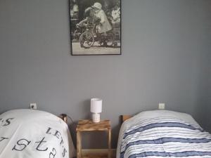 ein Schlafzimmer mit einem Bett und einem Bild an der Wand in der Unterkunft GITE DES BOULEAUX in Maîche