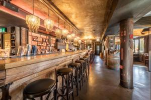 a bar with a row of stools in a room at feRUS Hotel in Lucerne