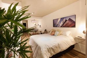 Alma de Agua Resort في فيديراسيون: غرفة نوم بسرير ابيض ونبات