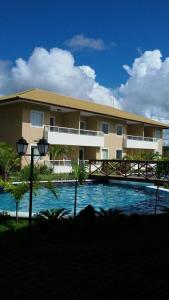 a building with a swimming pool in front of a building at Residencial Verano in Guarajuba